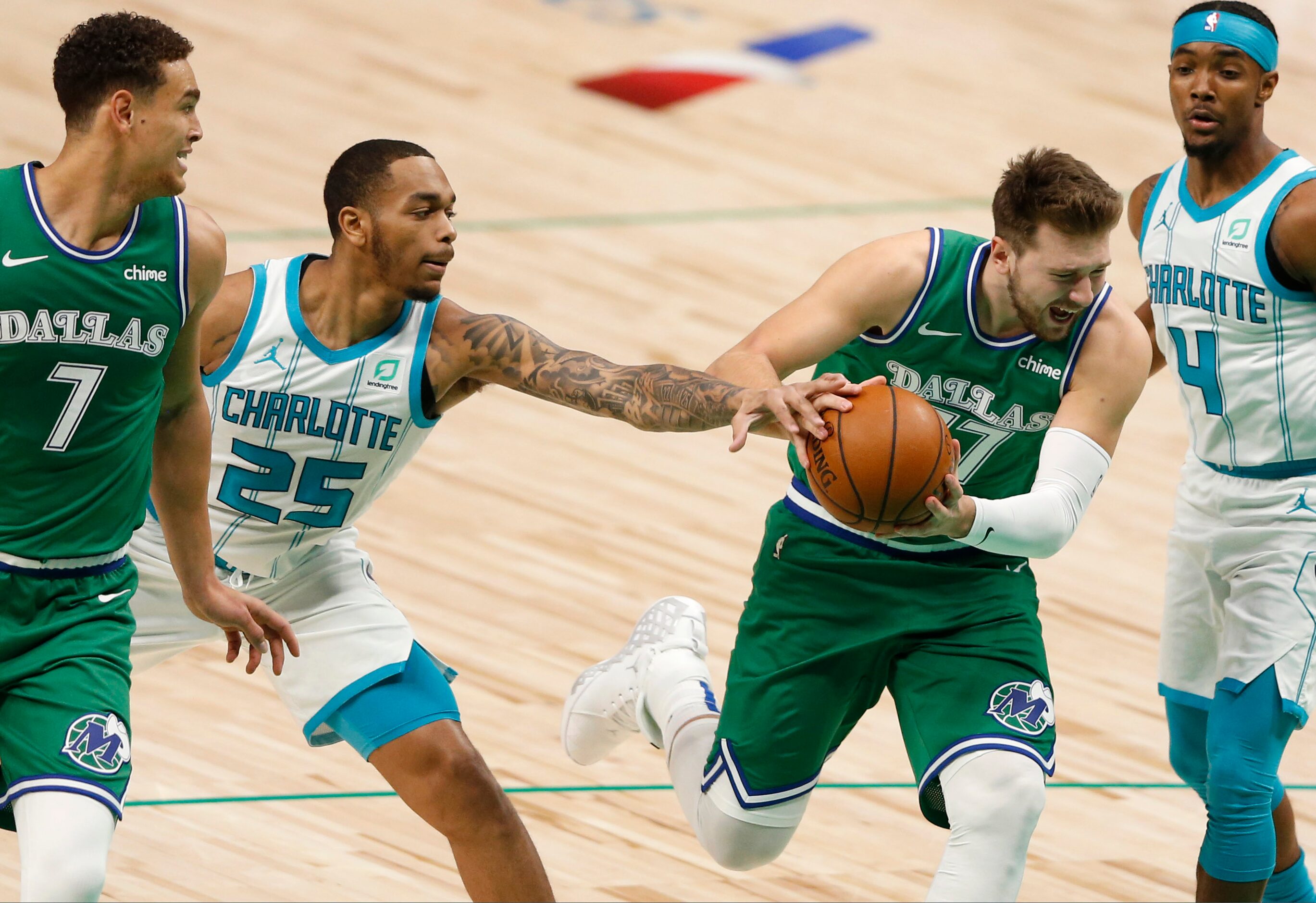 Dallas Mavericks guard Luka Doncic (77) is fouled by Charlotte Hornets forward P.J....