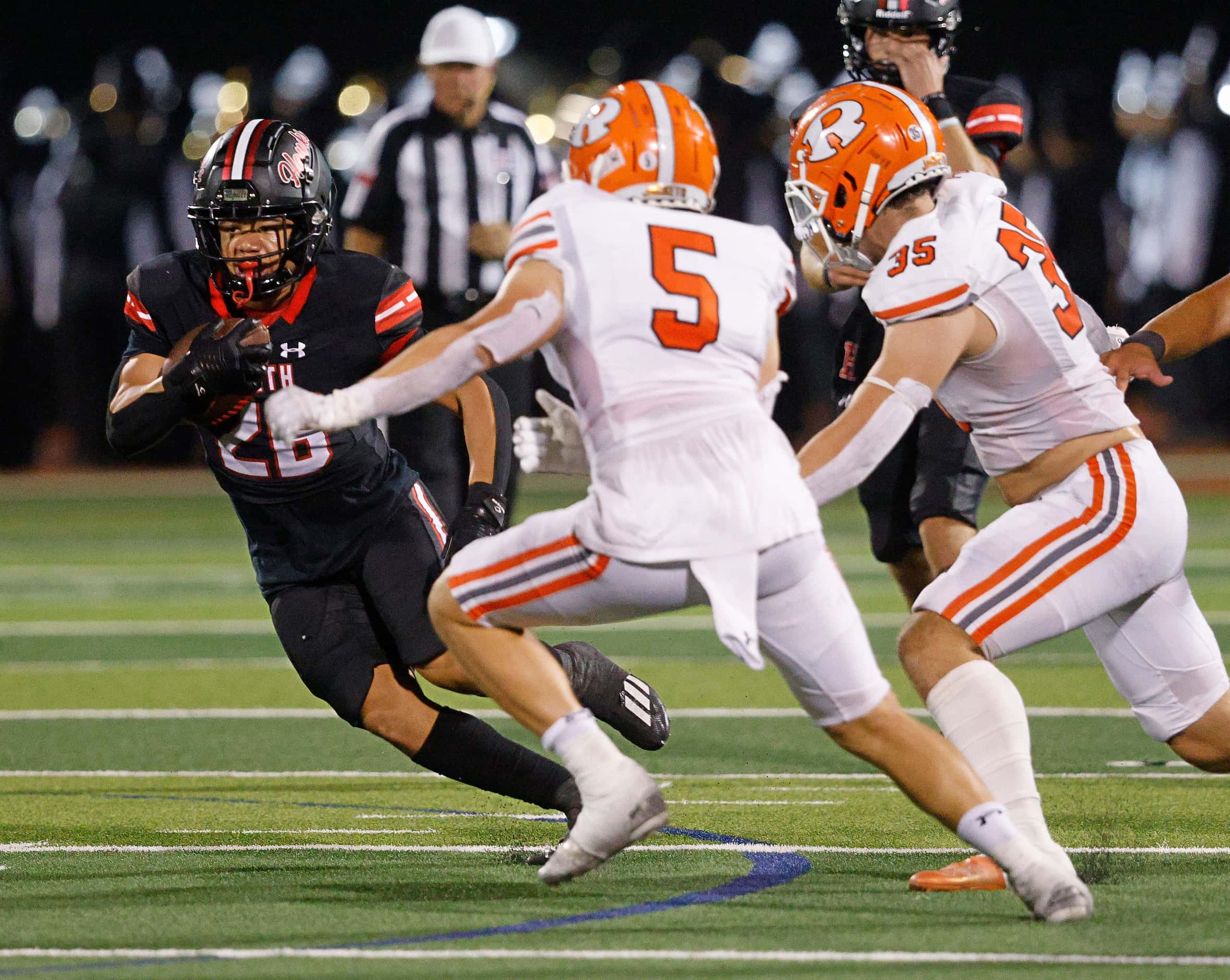 Rockwall-Heath's Hayden Gentry (26) keeps a ball away from Rockwall's Tanner Hart (5) and...