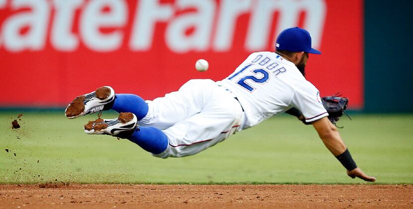 Texas Rangers second baseman Rougned Odor (12) dives for a grounder by Baltimore Orioles...