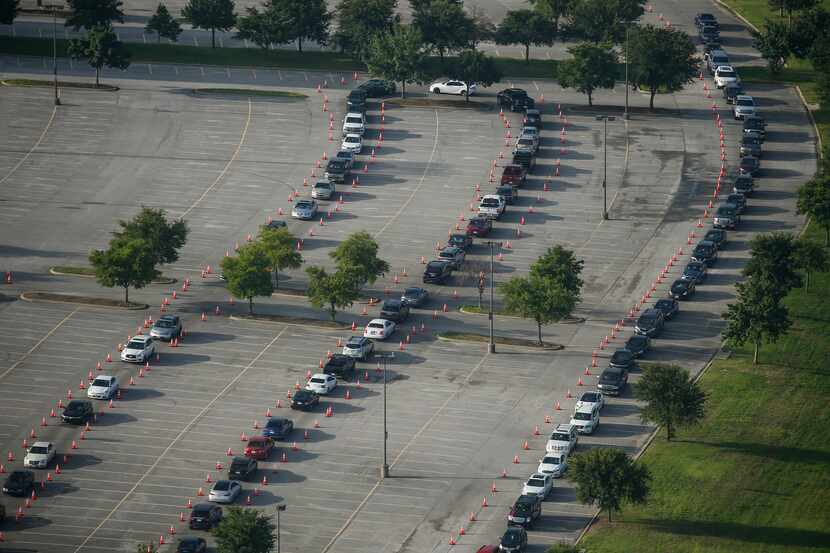 Hundreds of cars weave around the Ellis Davis Field House at a COVID-19 test site on Friday,...
