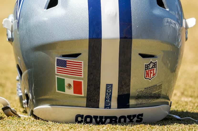 The helmet of Dallas Cowboys tackle Isaac Alarcón (60) features flags of both the United...