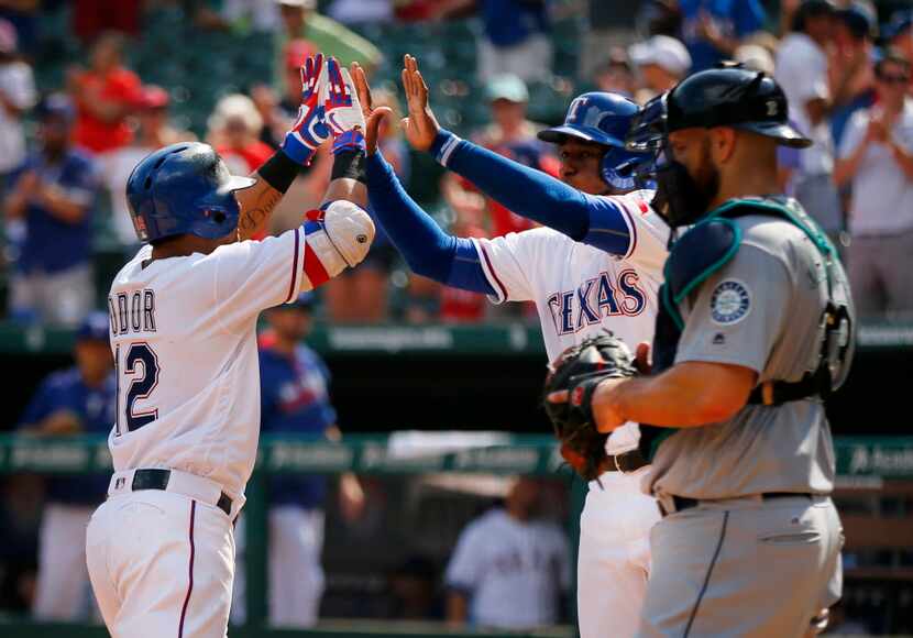 Texas Rangers second baseman Rougned Odor (12) is congratulated by Jurickson Profar (center)...