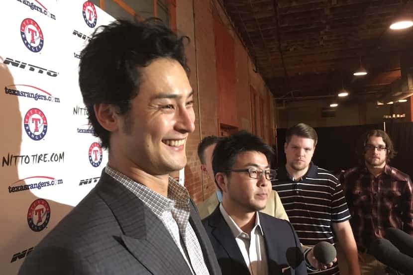 Texas Rangers pitcher Yu Darvish, left, smiles while speaking to reporters Friday, Jan. 20,...