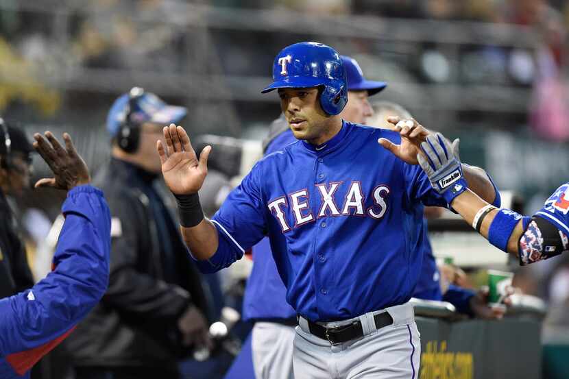 OAKLAND, CA - APRIL 22:  Alex Rios #51 of the Texas Rangers is congratulated by teammates...