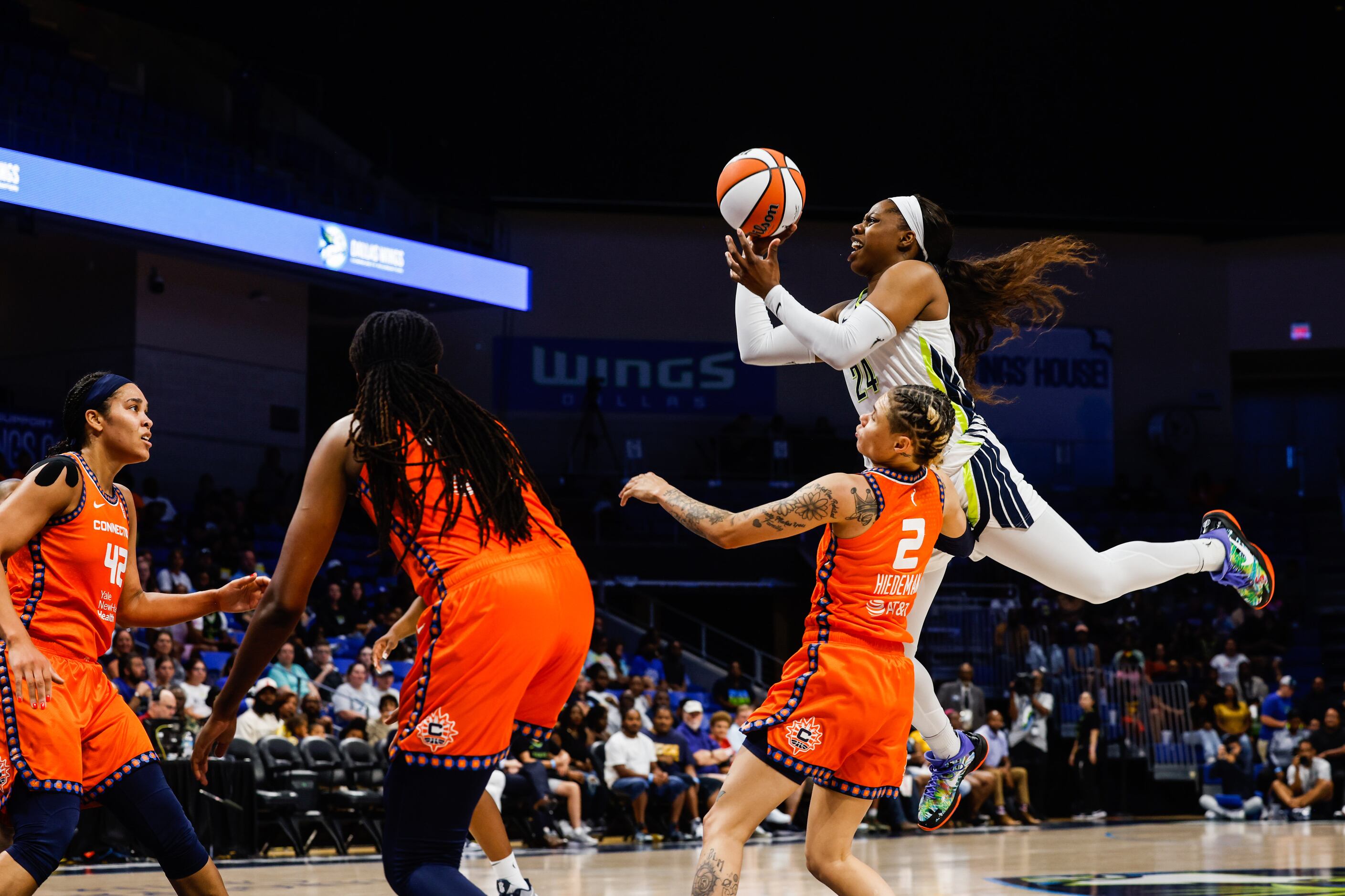 Dallas Wings guard Arike Ogunbowale (24) goes for a shot over Connecticut Sun guard Natisha...