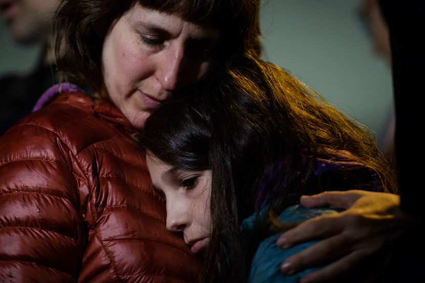 Rachel Kranson holds her daughter, Sasha Kranson, 12, during a vigil after a man fatally...