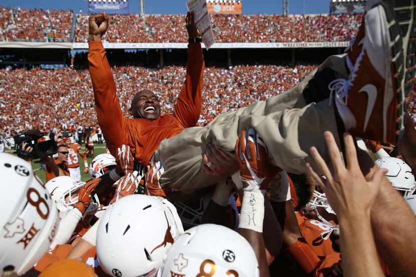 Texas head coach Charlie Strong is lifted by his players after their 24-17 win over Oklahoma...