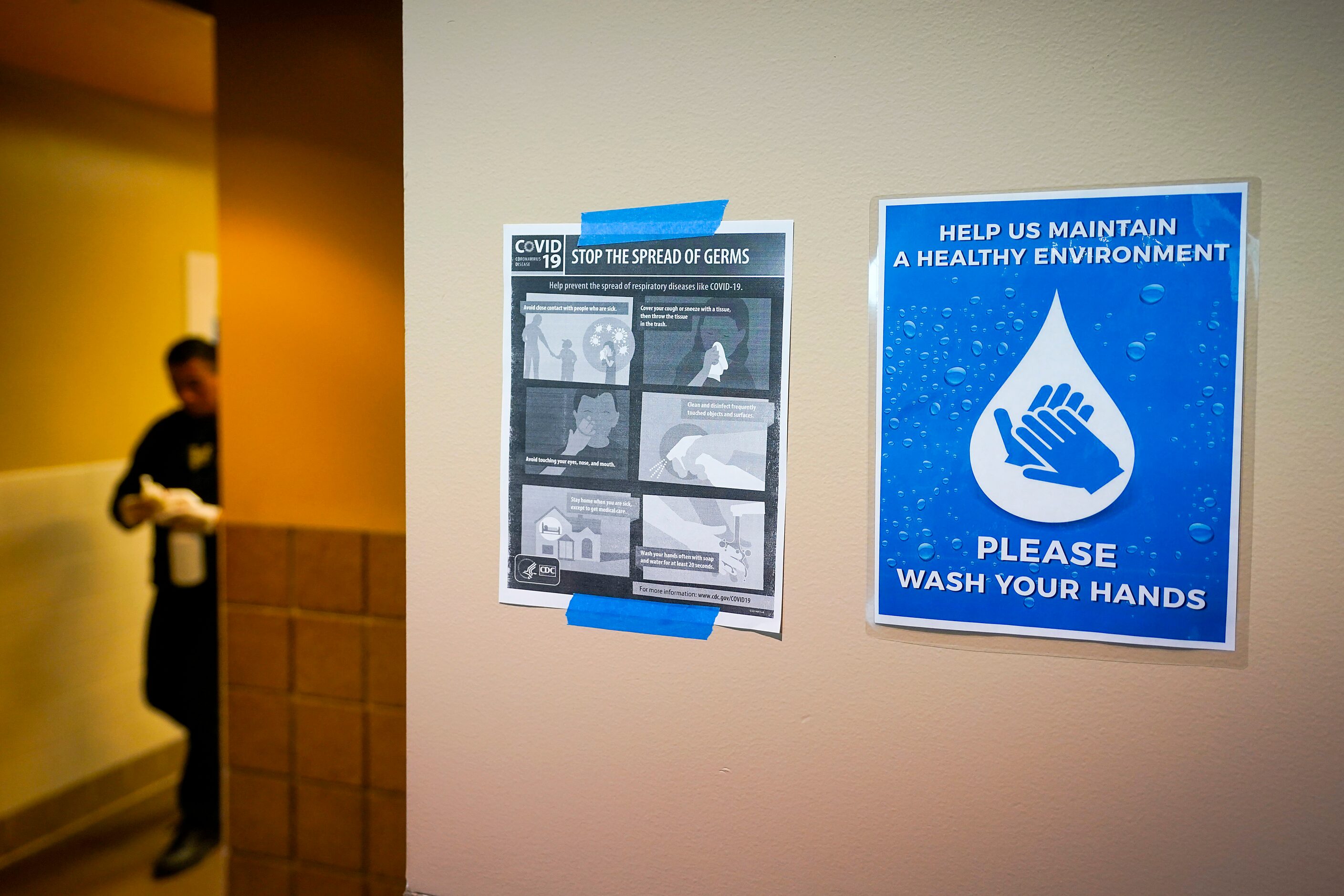 Signs advocate hand washing and CDC guidelines for stopping the spread of the new...