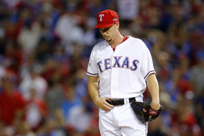 Texas Rangers relief pitcher Chi Chi Gonzalez hangs his head after giving up a three-run...