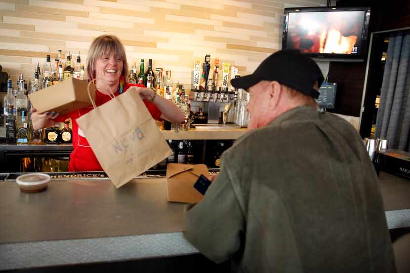Bartender Jody Aderhold (left) packages up regular Jim Harper's food order at Nova, a...