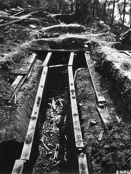 Bones of murdered prisoners still lay in an excavated air-raid trench, March 1945.  From As...