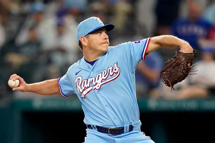 Texas Rangers starting pitcher Spencer Howard throws during the first inning of a baseball...