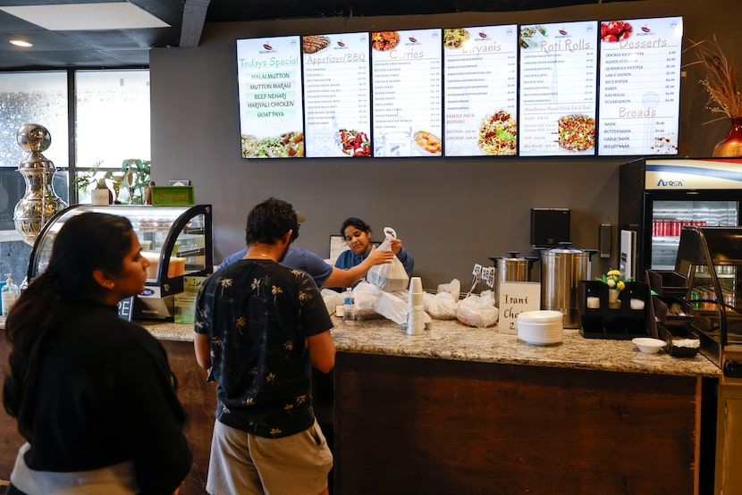 Customers line up to receive their orders on Tuesday, March 12, 2024  at Deccan Grill in...