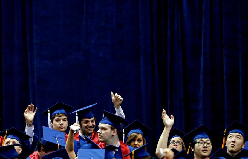 Students wave to family and friends in the audience during the SMU May Commencement...