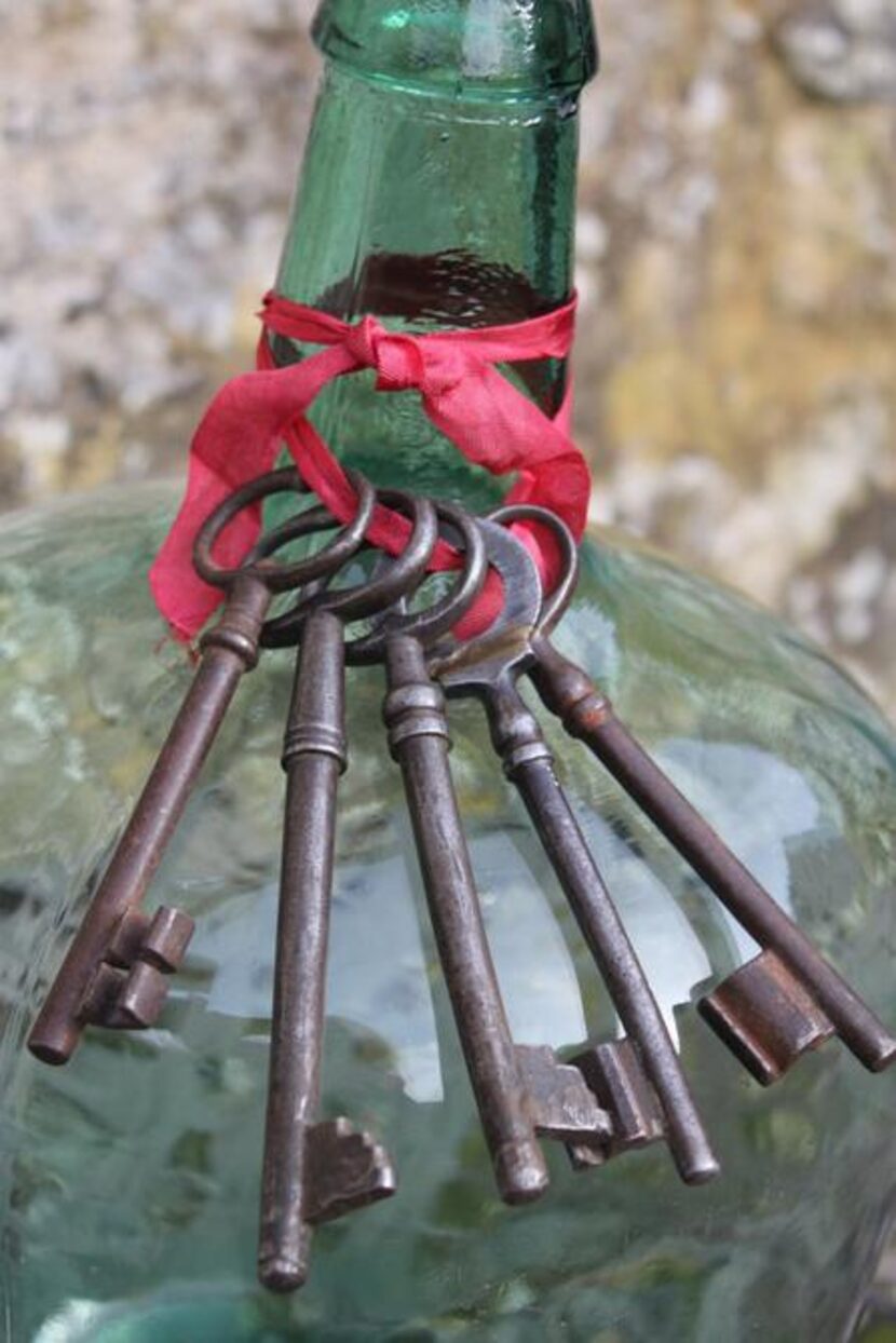 
Antique French keys tied to a vintage demijohn wine bottle 
