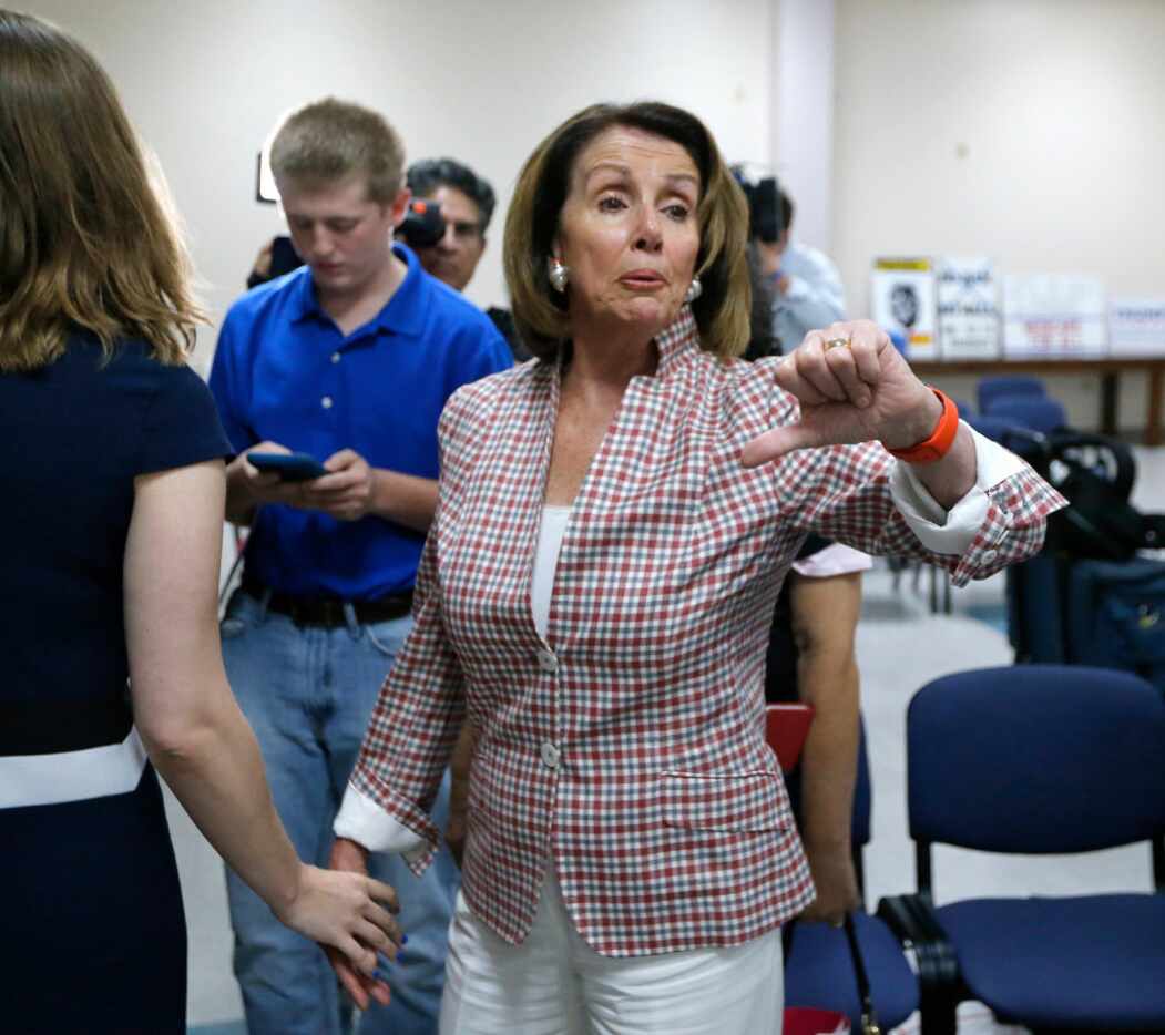Nancy Pelosi gives the thumbs down to somebody talking about the new health care plan during...