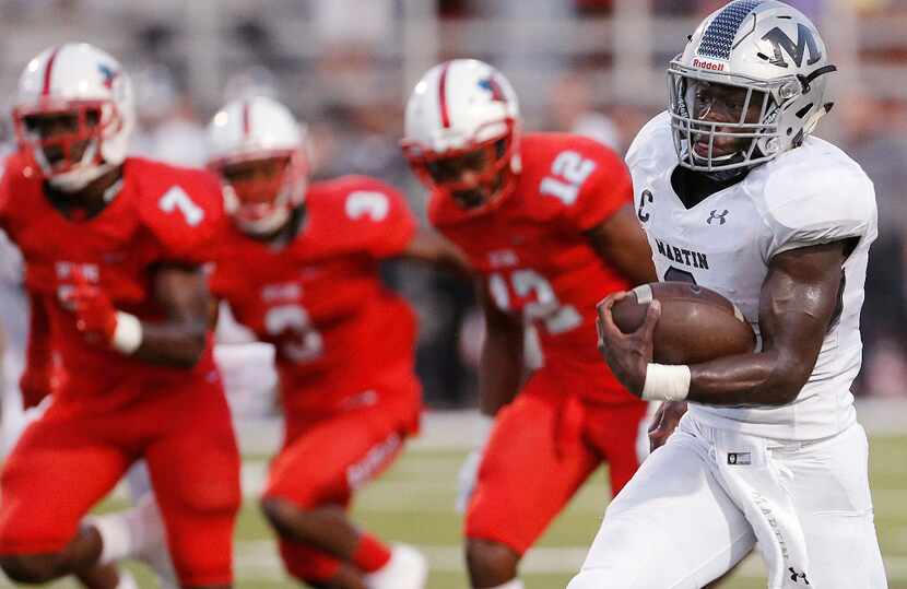 TXHSFB Arlington Martin senior quarterback Juma Otoviano (8) breaks past the Skyline defense...