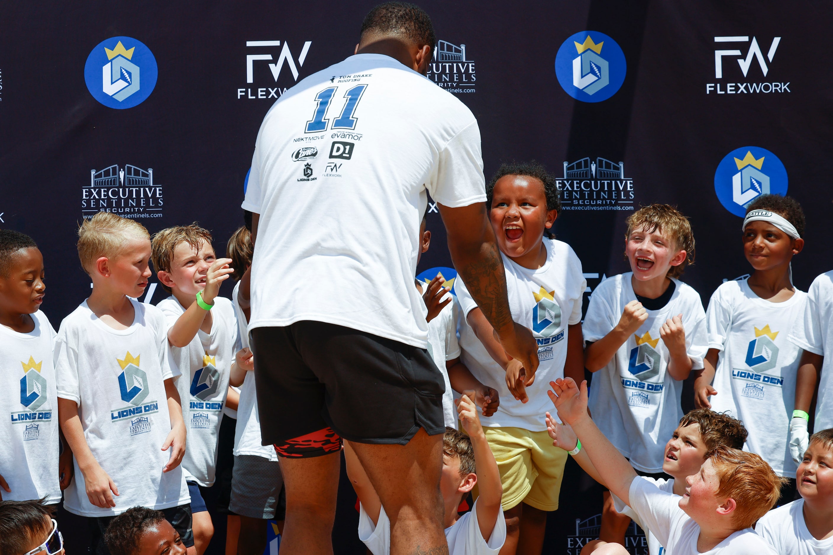 Dallas Cowboys linebacker Micah Parsons interacts with young football players at his youth...