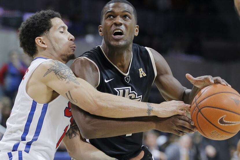UCF guard Daiquan Walker, right, battles SMU guard Nic Moore for space during the first half...