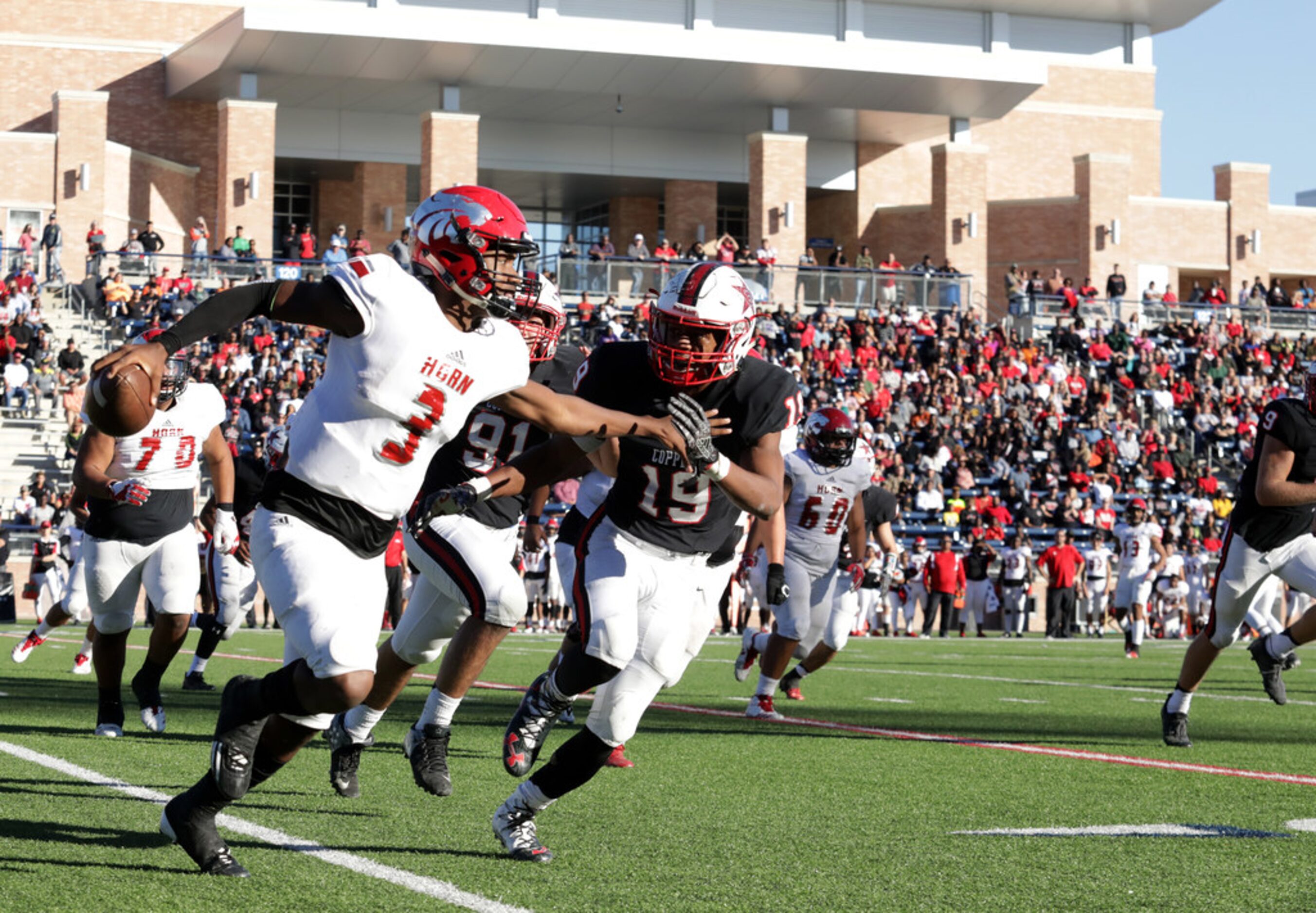 Horn player 3, Jermaine Givens, holds off Coppell player 19, Xavier Brown, during a Class 6A...