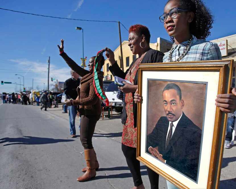 
Markayla Wright held a large portrait of Dr. Martin Luther King Jr. as she watched Monday’s...