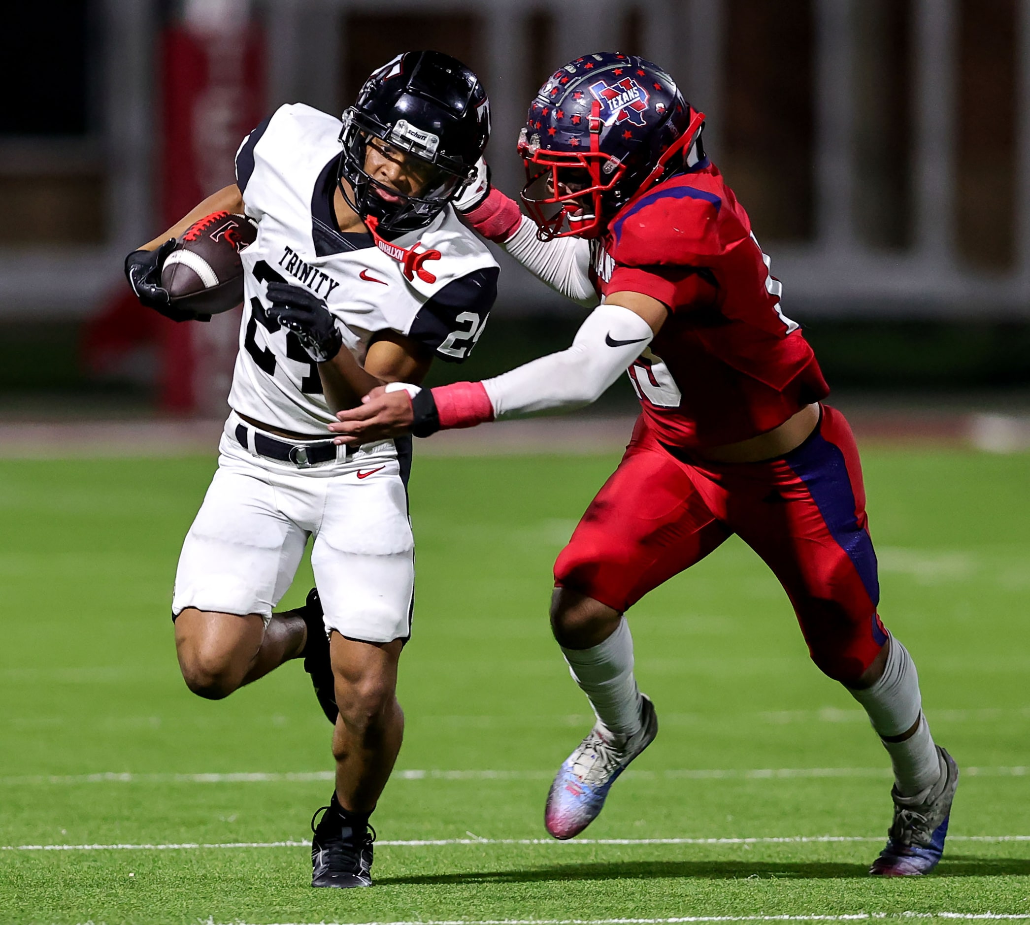 Trinity running back JT Harris (24) tries to break free from Justin Northwest linebacker...