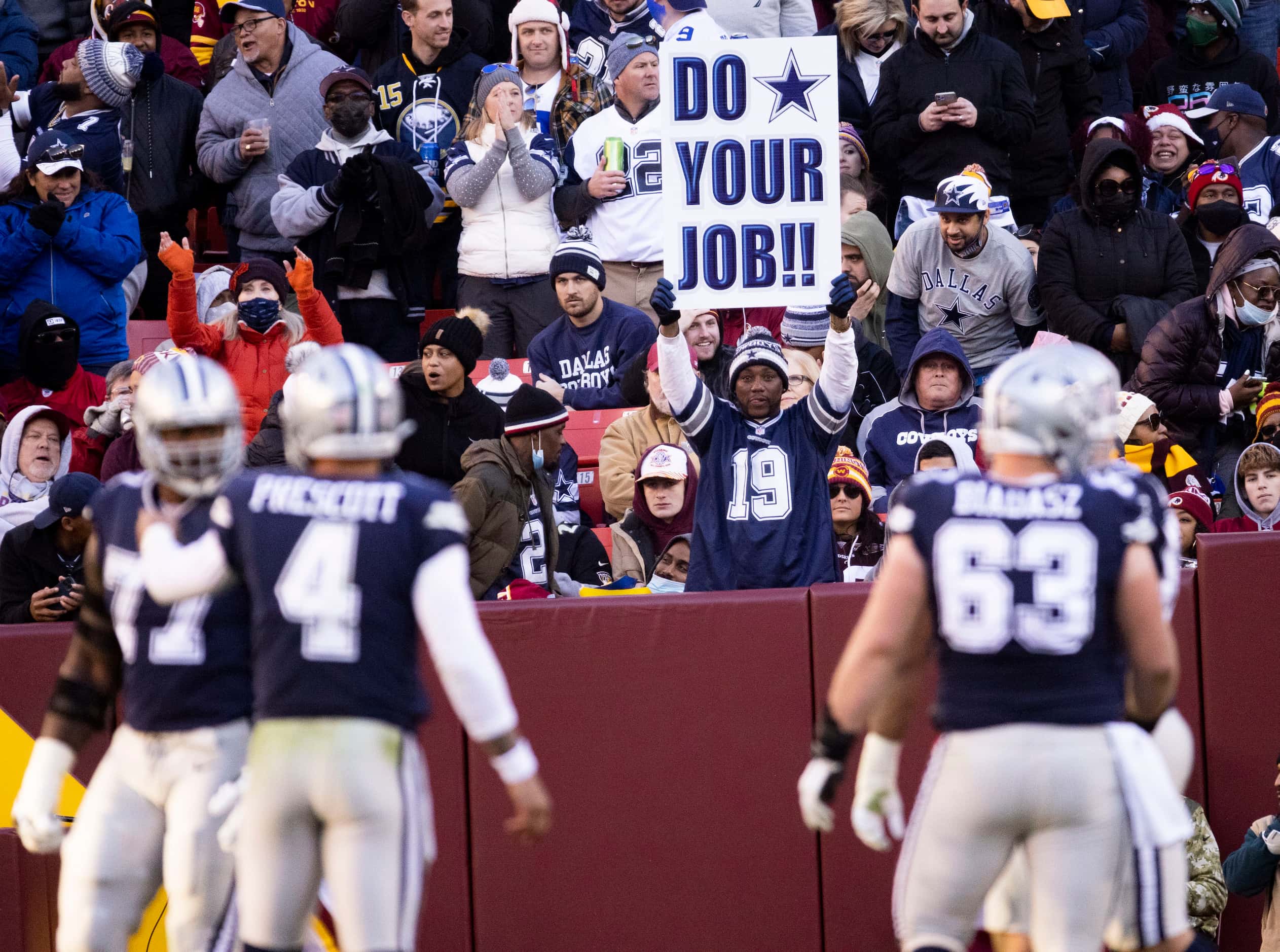 A Dallas Cowboys fan holds a sign saying “DO YOUR JOB” during the third quarter of an NFL...