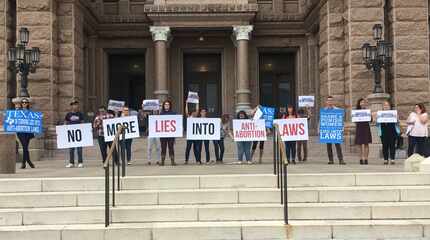 Protesters with the Texas Freedom Network hold signs outside the Texas Capitol on Thursday...
