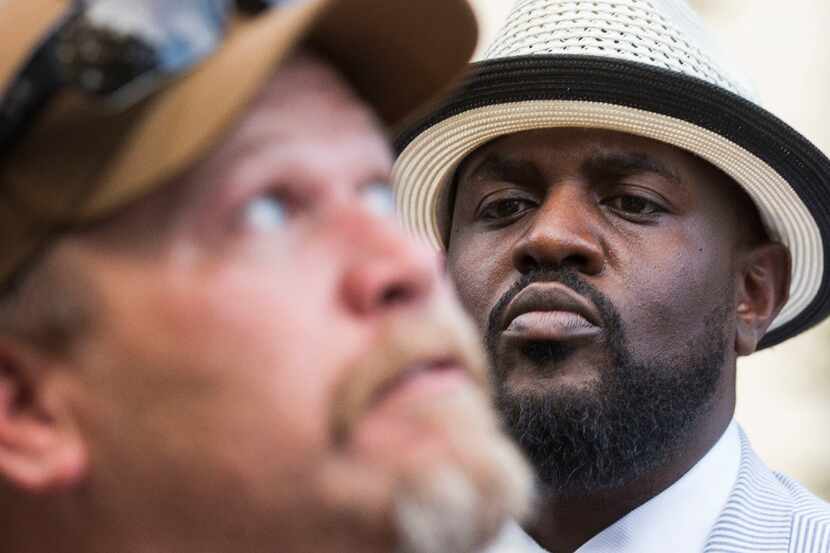 Pastor Michael W. Waters looks to counter-protester George Rick, who looks to a Confederate...