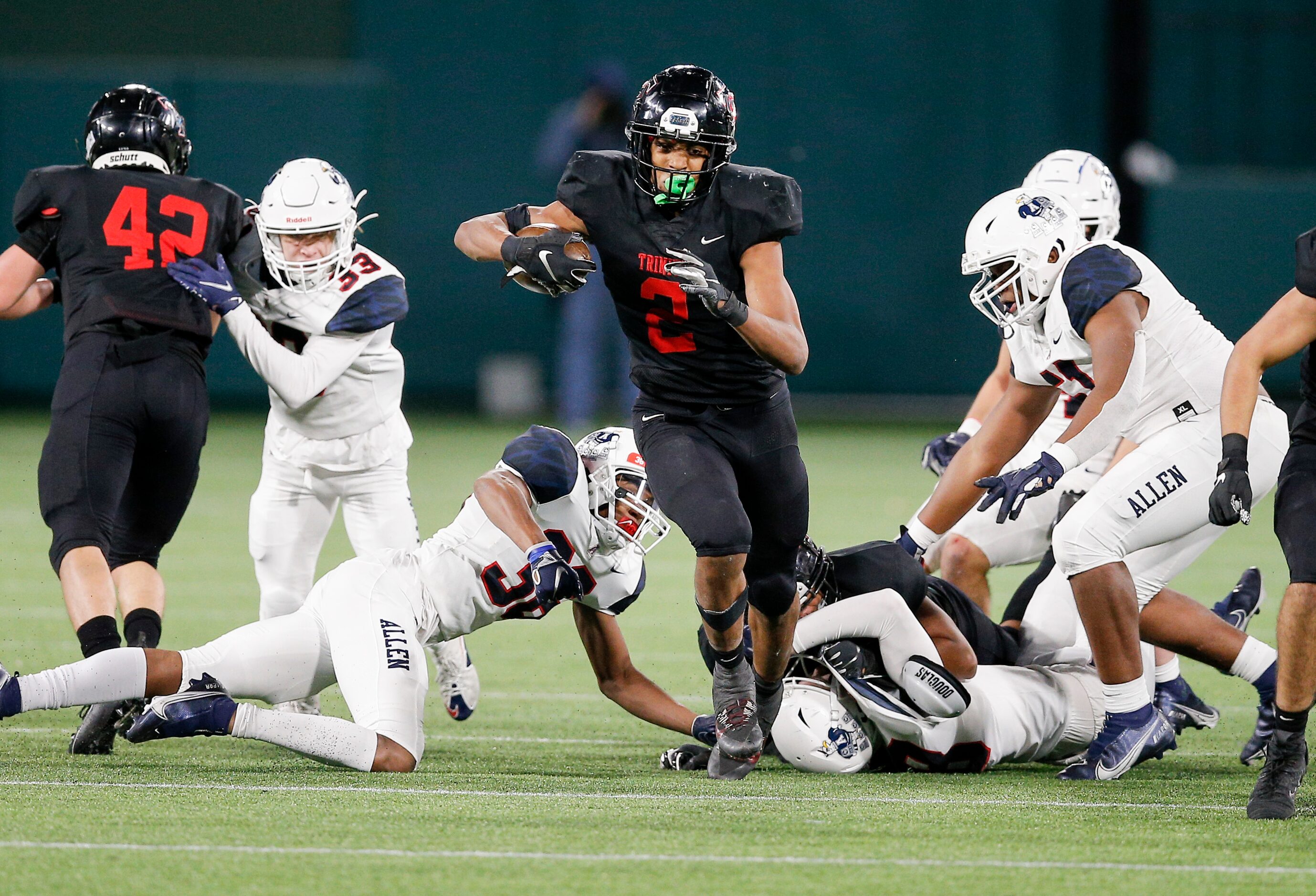 Euless Trinity junior running back Ollie Gordon (2) breaks through the Allen defensive line...