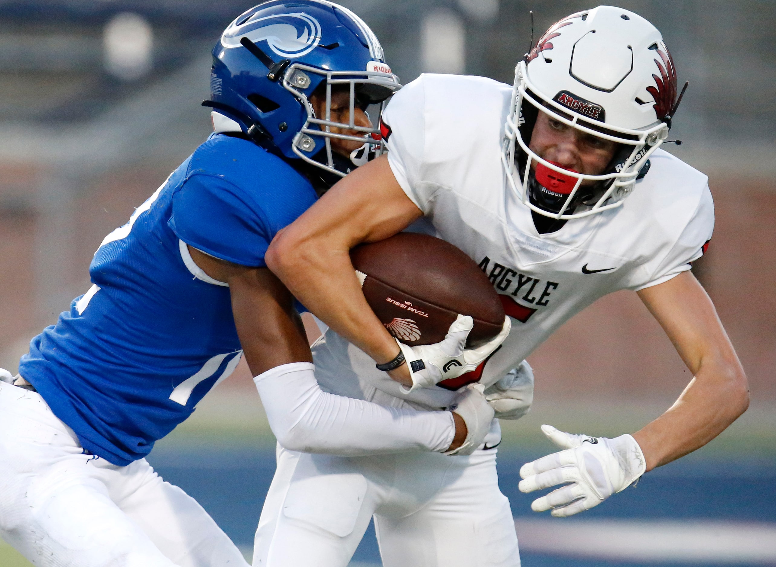 Argyle High School wide receiver Hayden Stewart (5) struggles for extra yardage as he is...