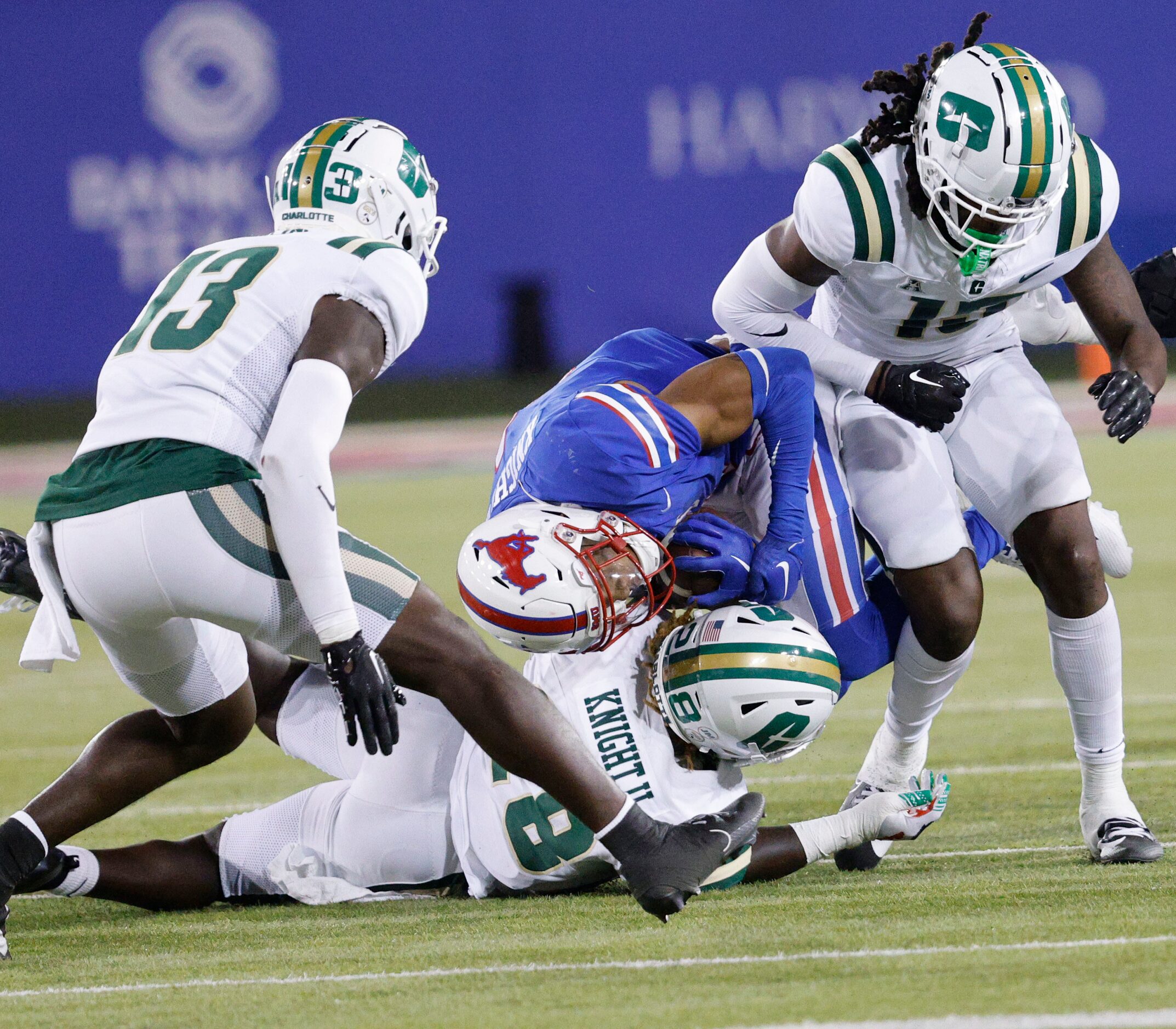 SMU running back Jaylan Knighton (4) is tackled by Charlotte 49ers linebacker Demetrius...