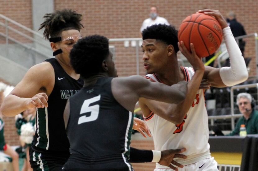 Rockwall guard Jamal Wiley (5), right, looks to pass out of a jam as he is guarded by...