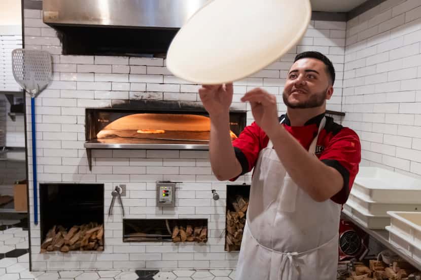 Jose Quezada tosses pizza dough into the air at DeLucca Gaucho Pizza & Wine in Dallas on...