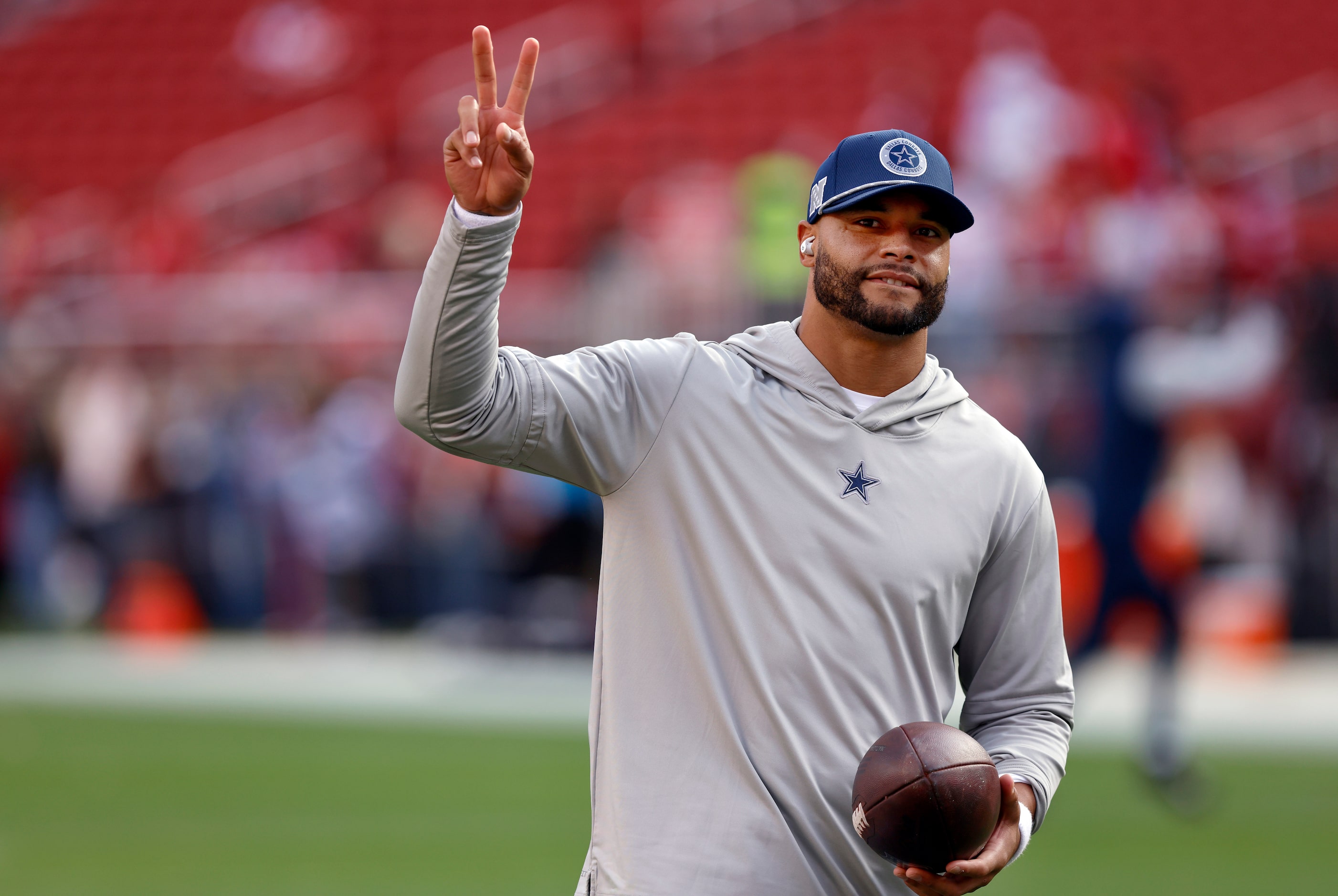 Dallas Cowboys quarterback Dak Prescott waves to cheering fans as he warms up before facing...