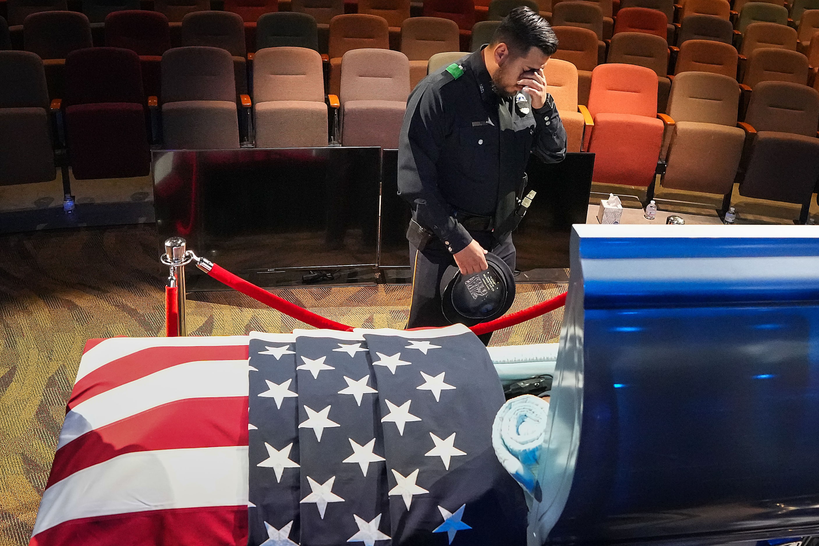 A Dallas police officer pauses at the casket of officer Darron Burks before funeral services...