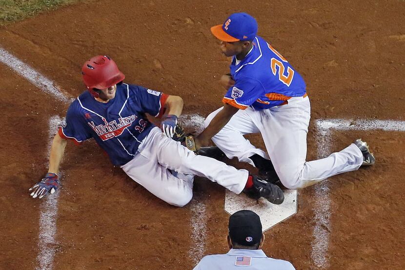 Endwell, New York's Ryan Harlost, left, scores on a wild pitch by Bowling Green, Ky.'s Devin...
