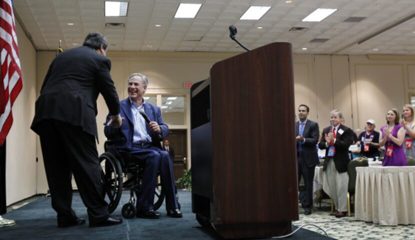 Texas Attorney General Greg Abbott (center) shakes hands with Republican Party of Texas...