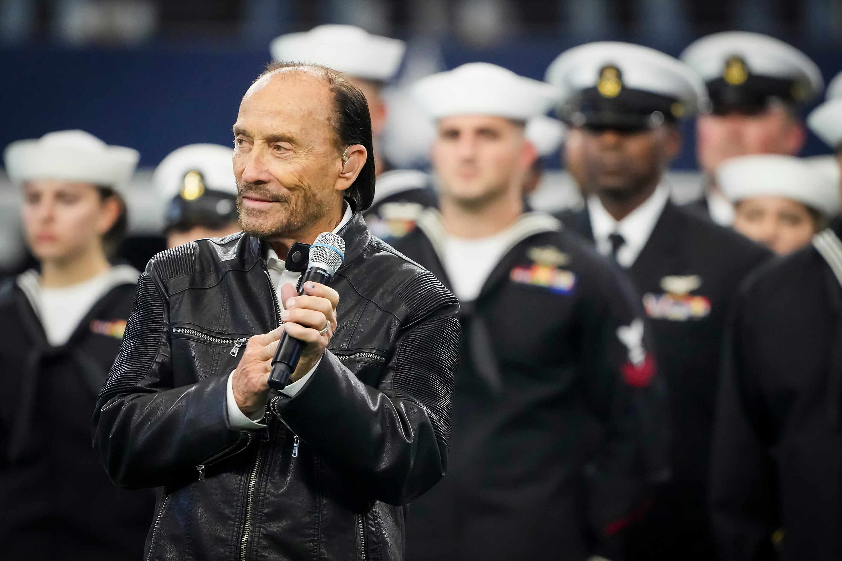 Lee Greenwood sings "God Bless the U.S.A." during halftime of an NFL football game between...