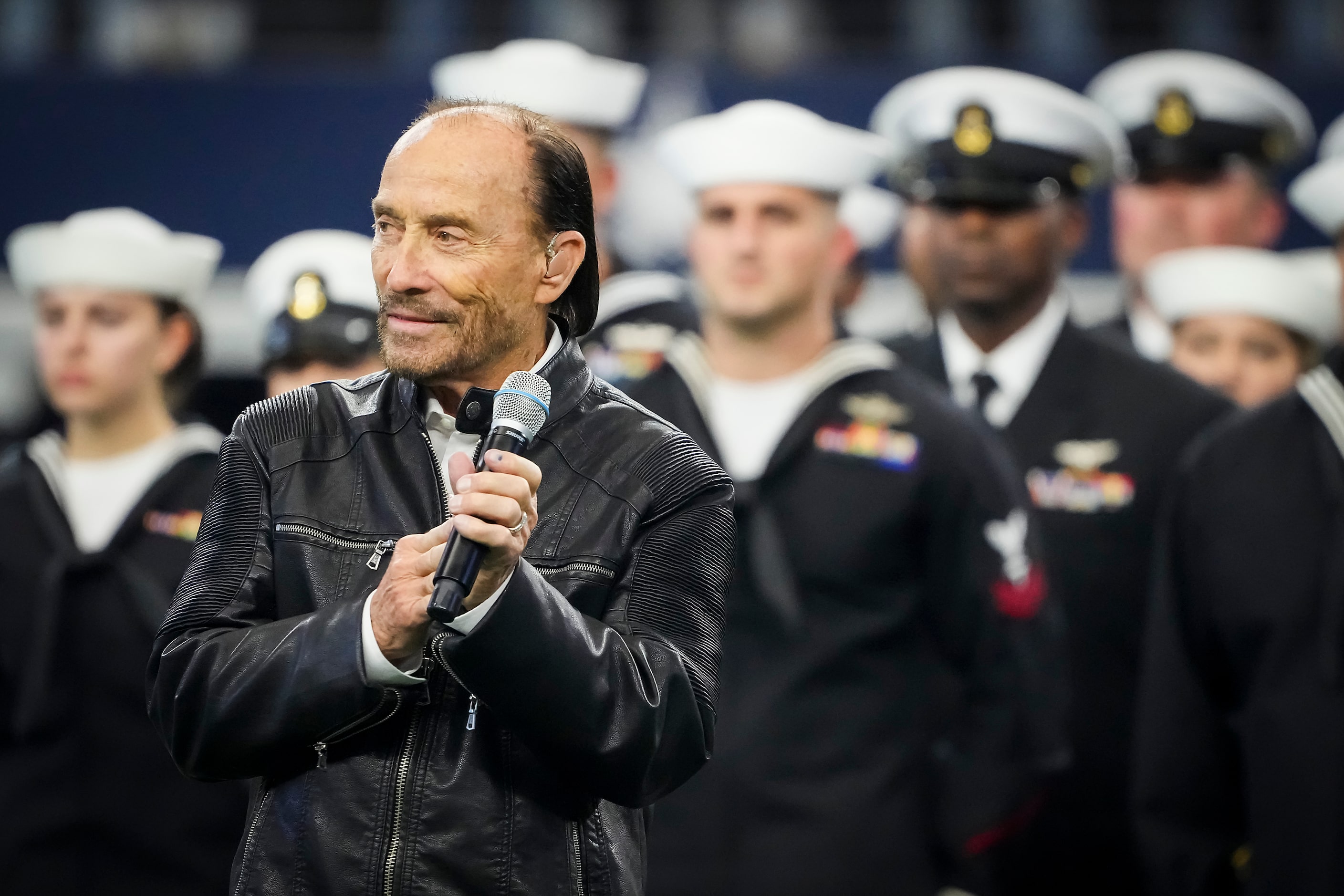 Lee Greenwood sings "God Bless the U.S.A." during halftime of an NFL football game between...