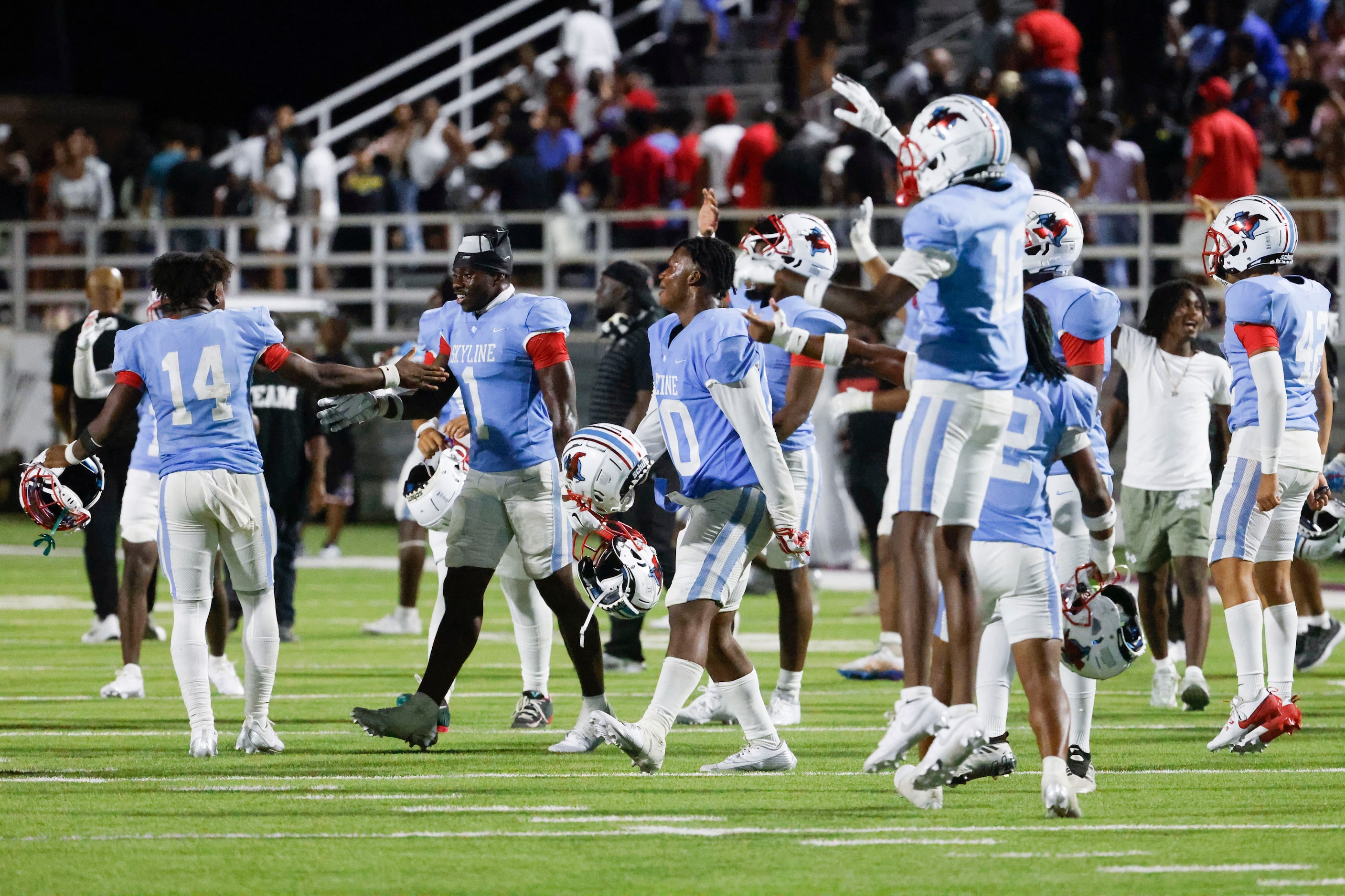 Skyline high players celebrate after winning a football game against North Forney, on...