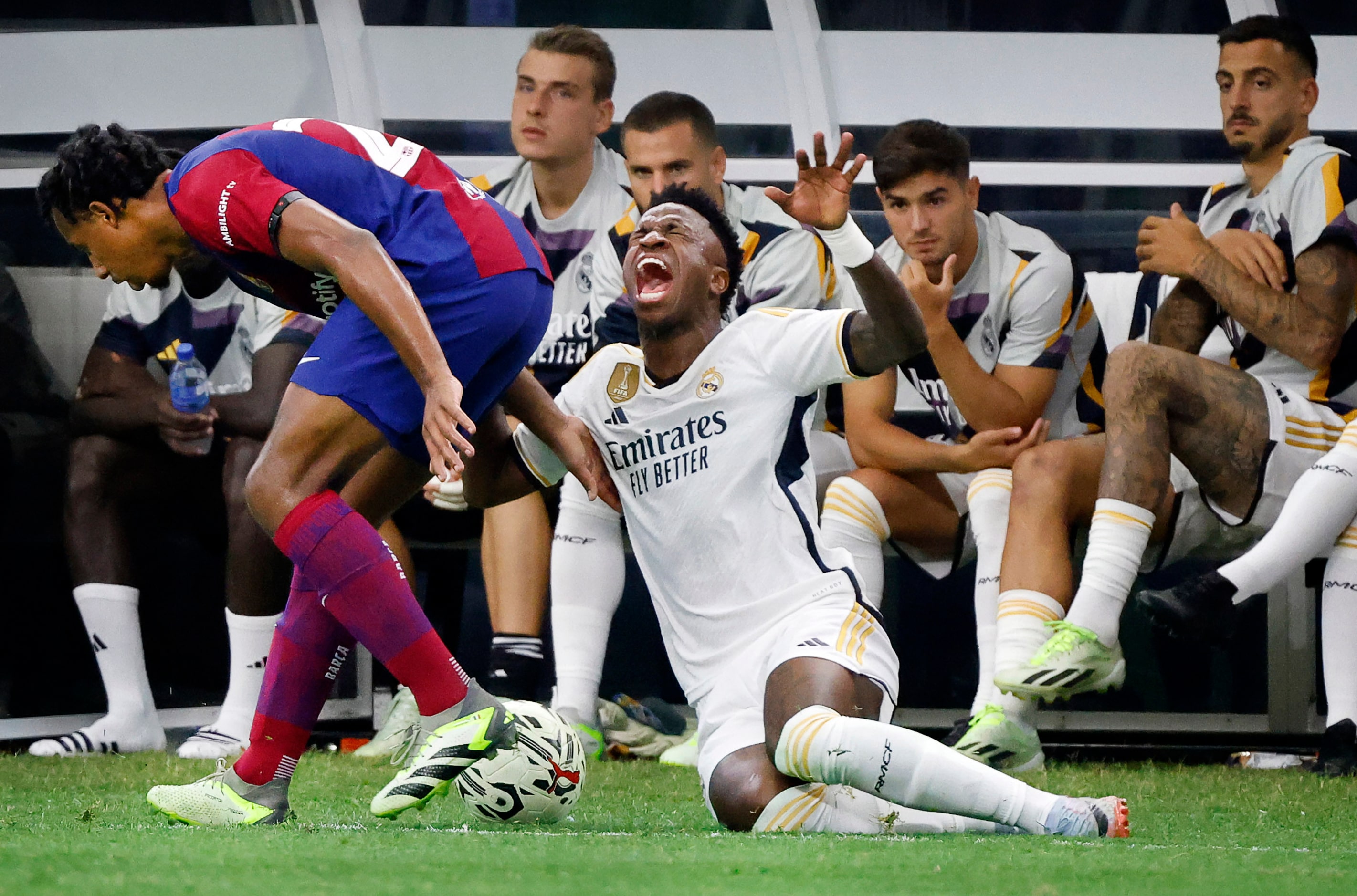 Real Madrid’s Vinícius Júnior (7) reacts after being taken down by Barcelona defender Jules...