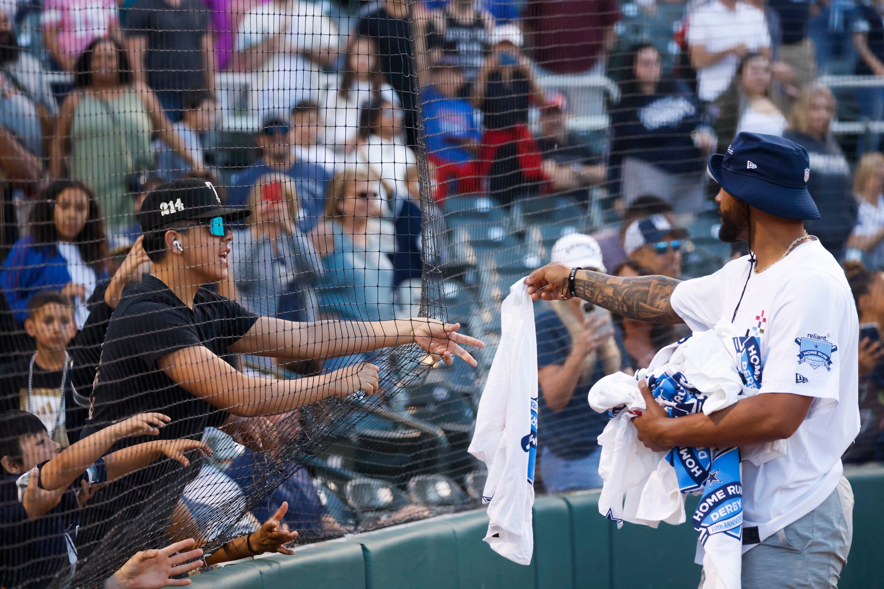 Dallas Cowboys QB Dak Prescott gives t-shirts to fans during the annual home run derby on...