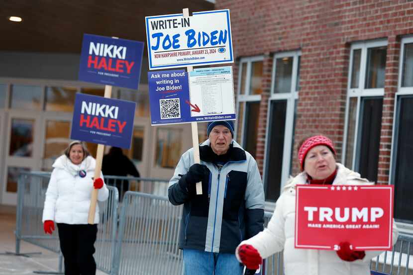 Candidate supporters stand outside a polling location in the presidential primary election,...