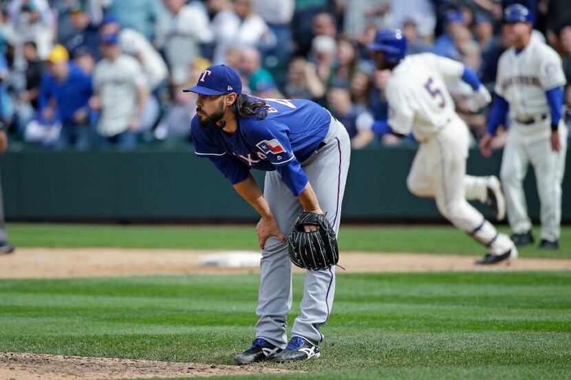 Texas Rangers relief pitcher Tony Barnette reacts on the mound as Seattle Mariners'...