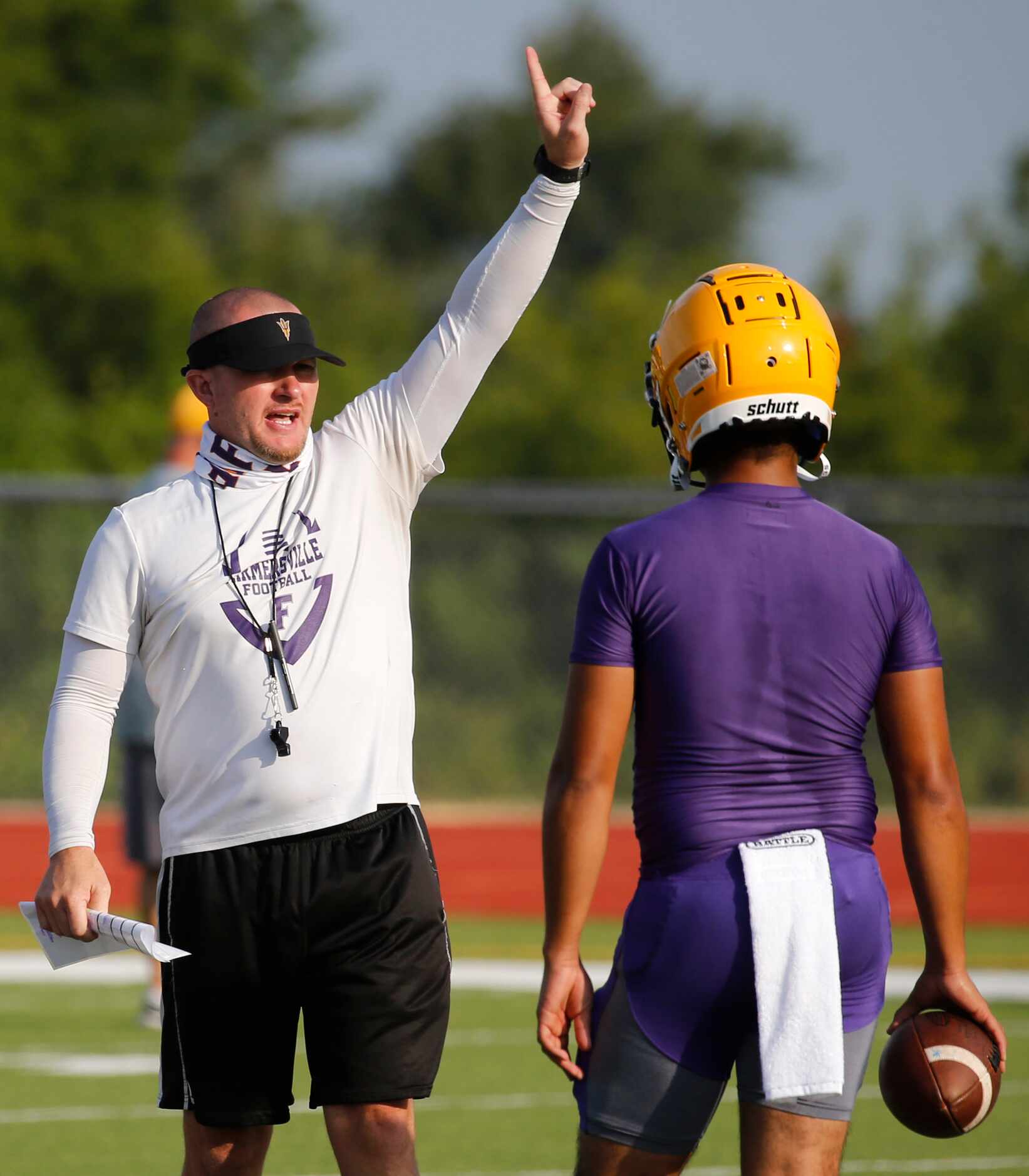 Farmersville High School head football coach Brandon Hankins calls out the next drill during...