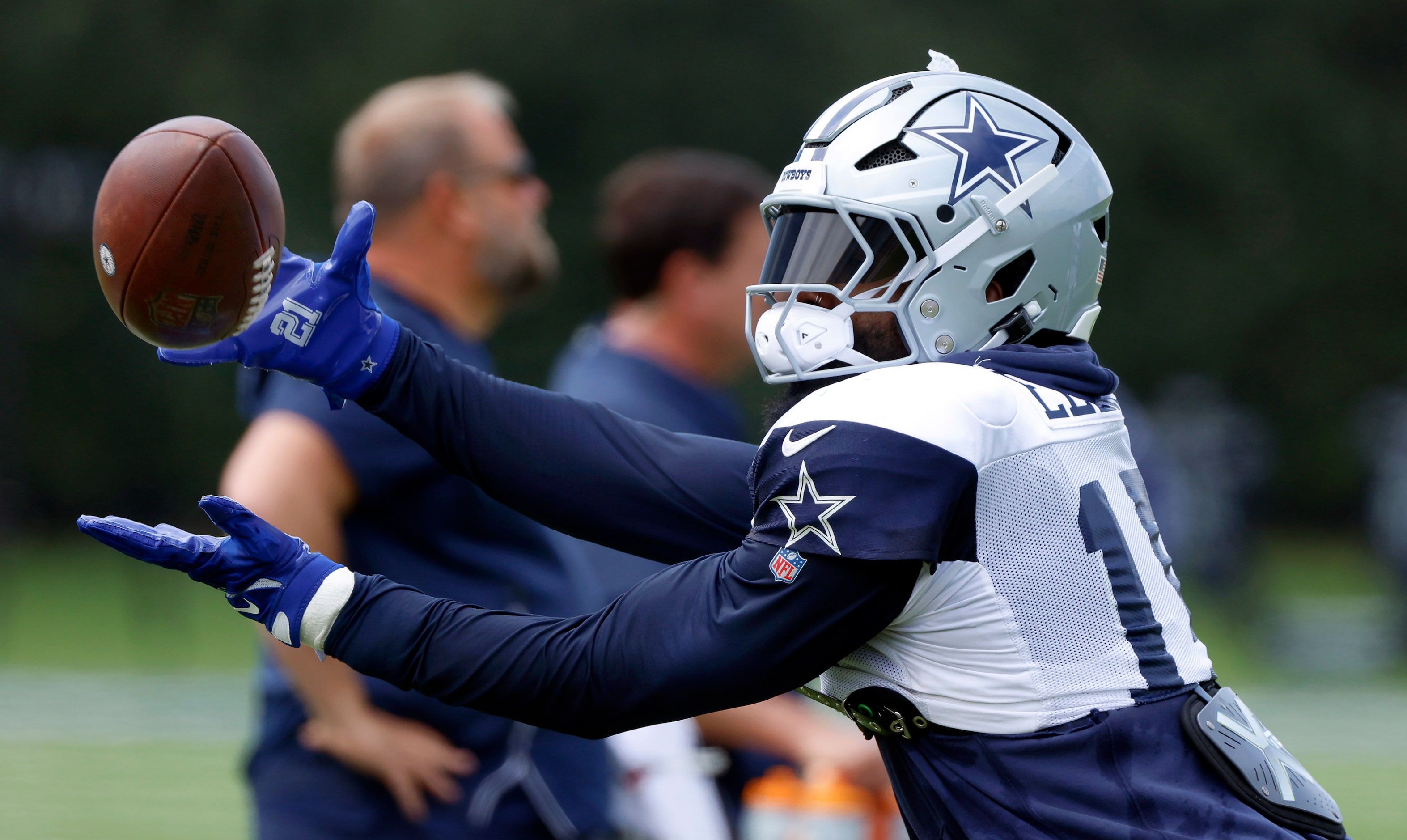 Dallas Cowboys running back Ezekiel Elliott (15) reaches for a pass as he warmed up during...