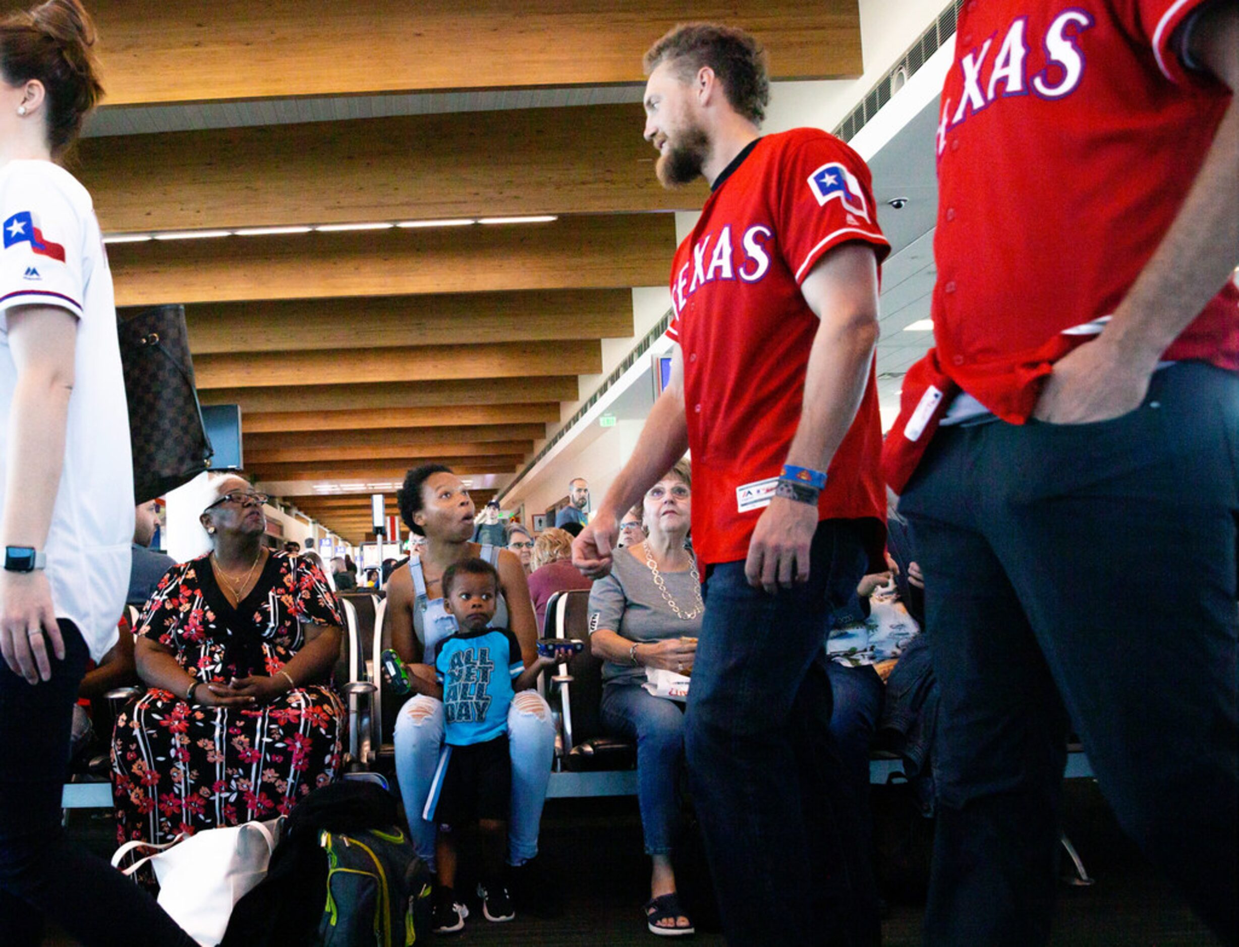 Lori Lee (left), Dominique Lee (center) and Elias Lee, 2, react to Texas Rangers right...