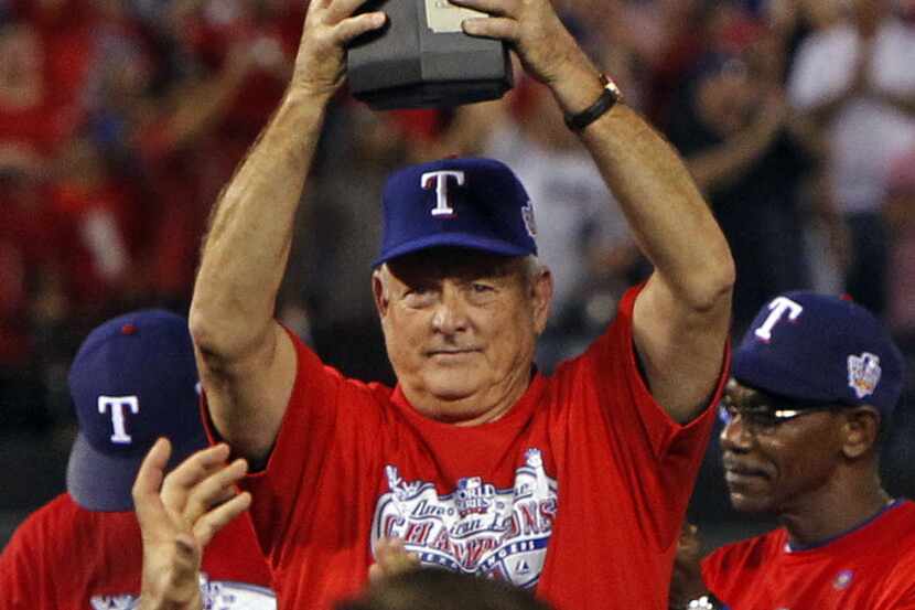 Texas Rangers president Nolan Ryan holds up the American League Championship trophy during...