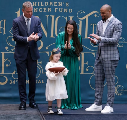 Dallas Cowboys greats Troy Aikman (left) & Dak Prescott (right) applaud model Paisley...